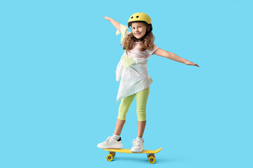 Cute little girl with skateboard and helmet on blue background