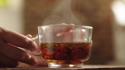 A steamy cup of tea held gently in hand, offering comfort and warmth Stock Video