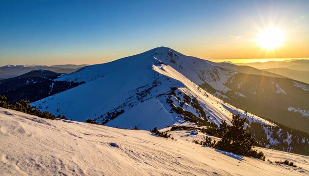 Snowy mountain range at sunrise, a bright sun shines, clear sky
