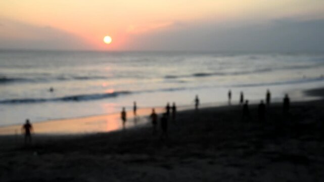 Silhouette of the people playing soccer on the beach during sun set