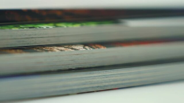 A close-up view of stacked magazines with colorful covers, creating a textural composition