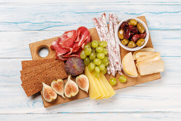 Antipasto platter with prosciutto, cheese, olives, salami, figs, grapes, and crackers
