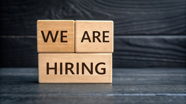 We are hiring message on wooden blocks with dark wooden background, symbolizing job opportunity and recruitment concept - Powered by Adobe