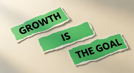 Inspiring message 'Growth is the goal' on torn green paper strips, symbolizing business success and forward momentum