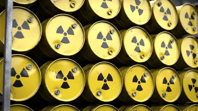A stack of yellow barrels marked with black radiation symbols, stored indoors. Concept for industrial, scientific, or environmental themes.