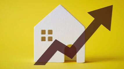 A white house model with an arrow overlay on a bright yellow background symbolizes property value increase, real estate market growth, and home appreciation in a studio shot.