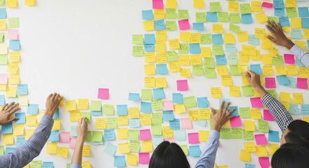 Diverse team collaborating using colorful sticky notes on whiteboard