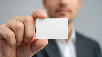Man holding blank business card close to camera with focus on card surface