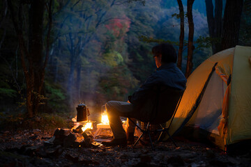 夕暮れのソロキャンプ を楽しむ男性