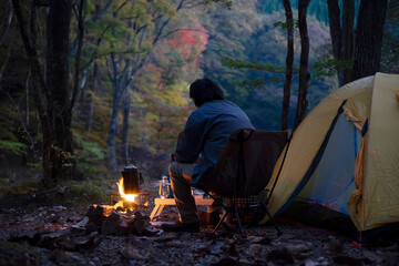 夕暮れのソロキャンプ を楽しむ男性