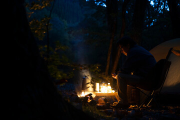 夕暮れのソロキャンプ を楽しむ男性