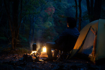 夕暮れのソロキャンプ を楽しむ男性