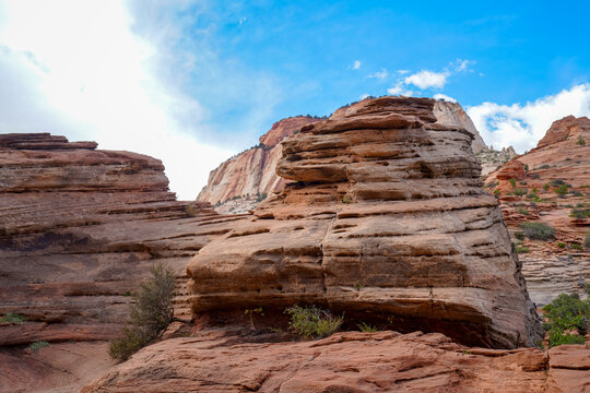Rounded sandstone formations stand against bright desert sky, highlighting the textured rock layers near Angel&rsquo;s Landing in Zion National Park.