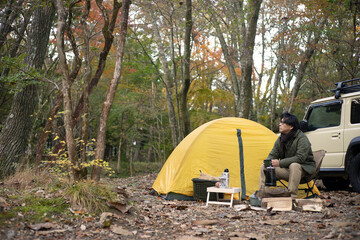 秋のソロキャンプ を楽しむ男性