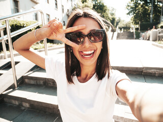 Portrait of young beautiful smiling hipster woman in trendy summer jeans shorts. Sexy carefree...
