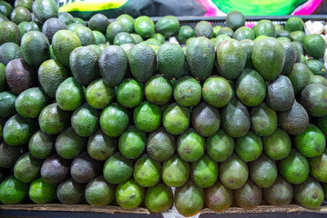 Fresh Stacked Ripe Hass Avocado Fruit Display in Market Setting