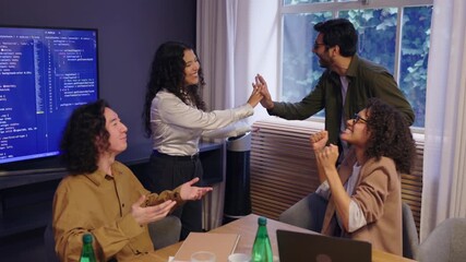 Diverse group of coworkers celebrating success and giving high fives during business meeting in modern office showing teamwork energy collaboration and positive professional atmosphere