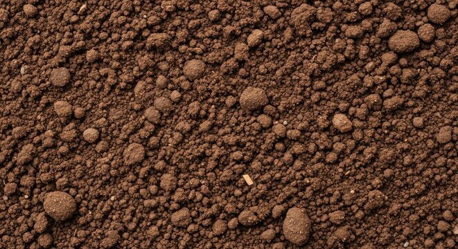 Extreme closeup of finely ground dark soil, showcasing its granular texture and rich, earthy tones, ideal for background or abstract natural imagery