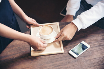 Close up hands of man sitting office desk holding sweet coffee cup relax and enjoy with happy time. Hot coffee mug in hand. Man holding coffee cup relaxing after work at office warm taste in cafe