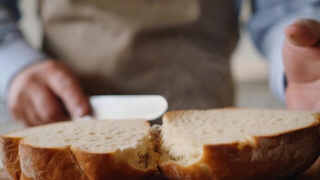 A close-up shot of a person slicing bread on a cutting board, creating a perfect meal. Stock Video