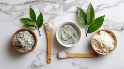“Flat lay of cosmetic clay products with dry powder and mixed clay mask, styled with a green leaf on a marble surface.”