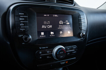 Center console of a 2017 red South Korean hatchback car showing screen, audio system, climate controls vents and dashboard layout in clean interior view. Great for automotive marketing and blogs