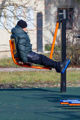A boy is sitting on a swing
