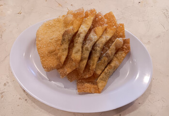 Indonesian Chinese cuisine, fried dumplings filled with sweet and savory chicken meat on white plate isolated on marble table.