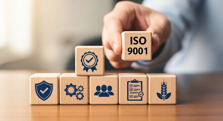 Hand placing ISO 9001 block onto QMS structure with icons for process management, audit documentation, teamwork, and agricultural food safety symbols, emphasizing core system components
