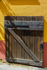 old wooden cellar door on a colorful house facade