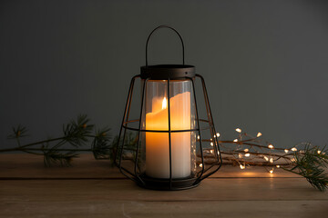 Vintage lantern with glowing candle and festive fairy lights