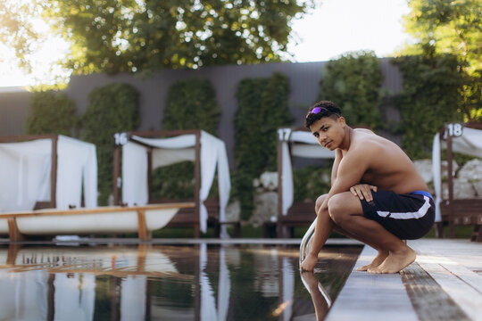 Young swimmer relaxing by the poolside on a sunny day