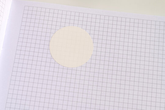 White circle sticker on grid paper background