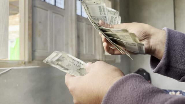 Closeup footage of hands counting cash and money. An employee counting indian rupees or indian currency money which he get from Bank. Person having cash in his hand for billing and payment.