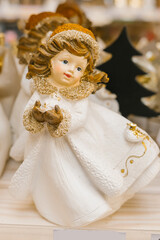 Fototapeta premium Elegant ceramic angel figurine with golden accents in winter attire