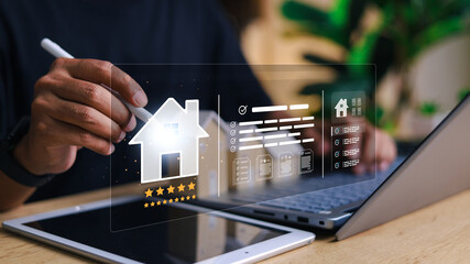 Person using digital tablet and laptop with virtual real estate interface, featuring house icon, rating stars, documents, and property checklist. Concept of smart property management.