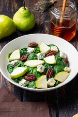Salad with spinach, blue cheese, pear, and nuts. Healthy eating. Vegetarian food.