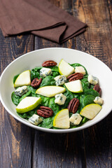 Salad with spinach, blue cheese, pear, and nuts. Healthy eating. Vegetarian food.