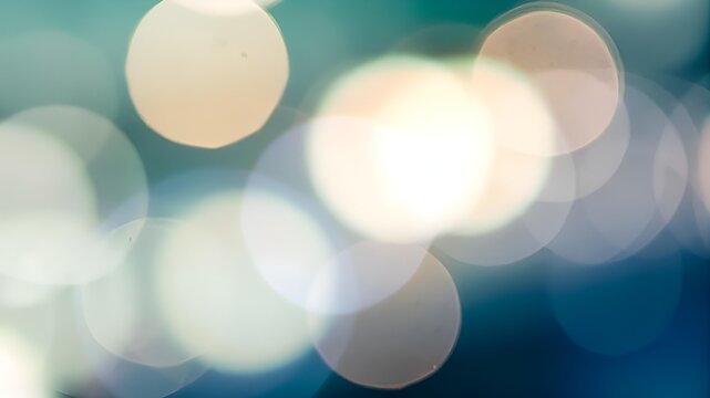 Blue and gold abstract background made in camera with a macro lens creating floating orbs of warm yellow light on a blue green backdrop