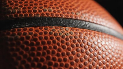 Close-up of a basketball's texture and details, showcasing the orange leather and black lines - Powered by Adobe