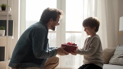 Sharing a Moment: A father extends a gift to his son in a warm embrace of affection and appreciation, highlighting the bond between family. Capturing a precious exchange of love and connection.