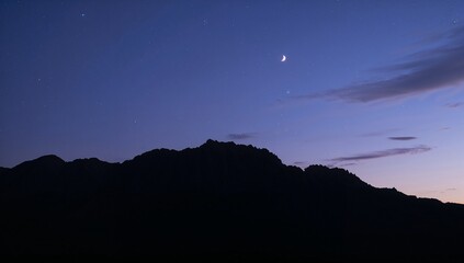 Serene Evening Landscape with Crescent Moon and Twinkling Stars