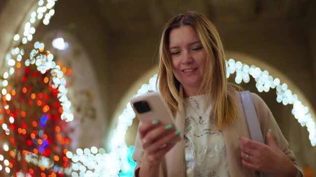 Female traveler inspecting schedule beside market stall, urban woman checking her travel app at night market, trip planner assessing details on her phone amid city lights and festive ambiance