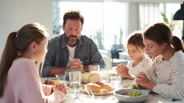 Family Prayer Gathering: A family pauses for a moment of reflection and gratitude around a dining table, showcasing unity, togetherness, and spiritual connection.