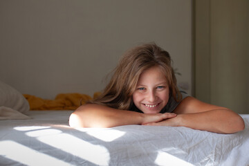 Happy Teenage Girl Relaxing in Bed in the Morning