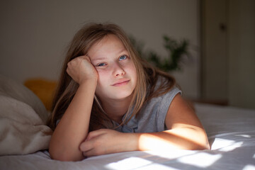 Happy Teenage Girl Relaxing in Bed in the Morning