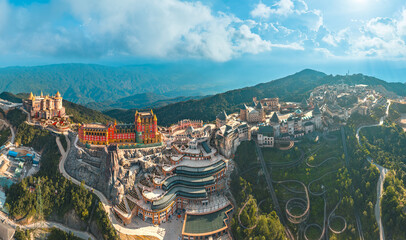 Aerial view of Ba Na Hills with castle, amusement park, hotels, buildings and beautiful university in Da Nang, a famous tourist destination in Vietnam, near the Golden Bridge.