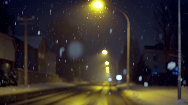 Snow swirls beneath a lone streetlight at midnight, each flake glowing softly in pale yellow light. The empty road drifts into gentle blur, creating a cinematic, quiet, and deeply lonely winter mood.
