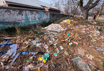 A closeup photo of a wall where "keep environment clean" is written but there is so much dirt dust house waste and polythene making environment polluted and dirty. House waste on road, polythene dust.