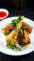 Crispy Asian Spring Rolls with Shrimp and Vegetables Served on a White Plate with Sweet Chili Sauce
